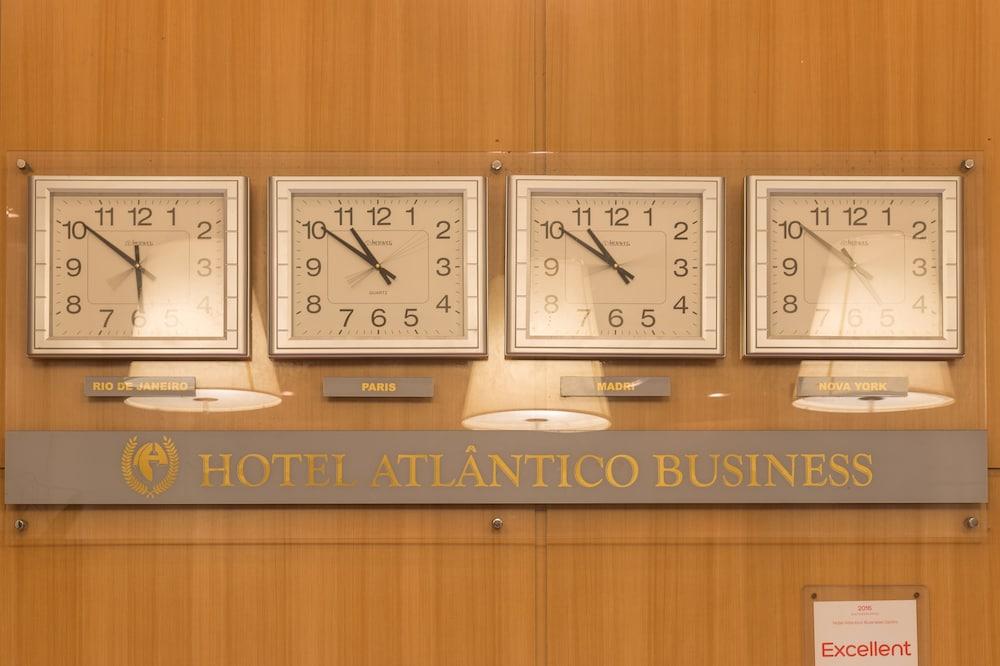 Hotel Atlantico Business Centro Ρίο ντε Τζανέιρο Εξωτερικό φωτογραφία The photo displays a wooden wall featuring three wall clocks. Each clock shows a different time, indicating that they are set to various time zones. Below the clocks, there is a sign that reads "HOTEL ATLÂNTICO BUSINESS." There are also two lamp fixt