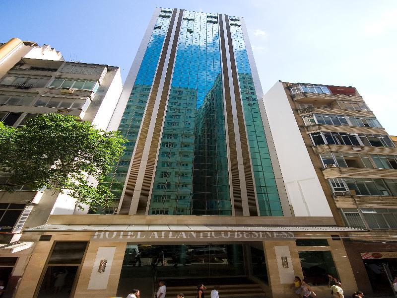 Hotel Atlantico Business Centro Ρίο ντε Τζανέιρο Εξωτερικό φωτογραφία The photo shows a modern hotel building, likely a high-rise, with a glass facade that reflects the sky. The hotel appears to have multiple stories, with vertical lines and a sleek design. At the base of the building, there is a sign that reads "Hotel